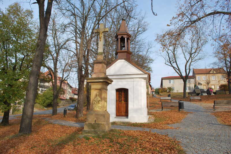 Jen pár kroků od busty Václava Svobody Plumlovského stojí pod korunami stromů kaple  s křížem,